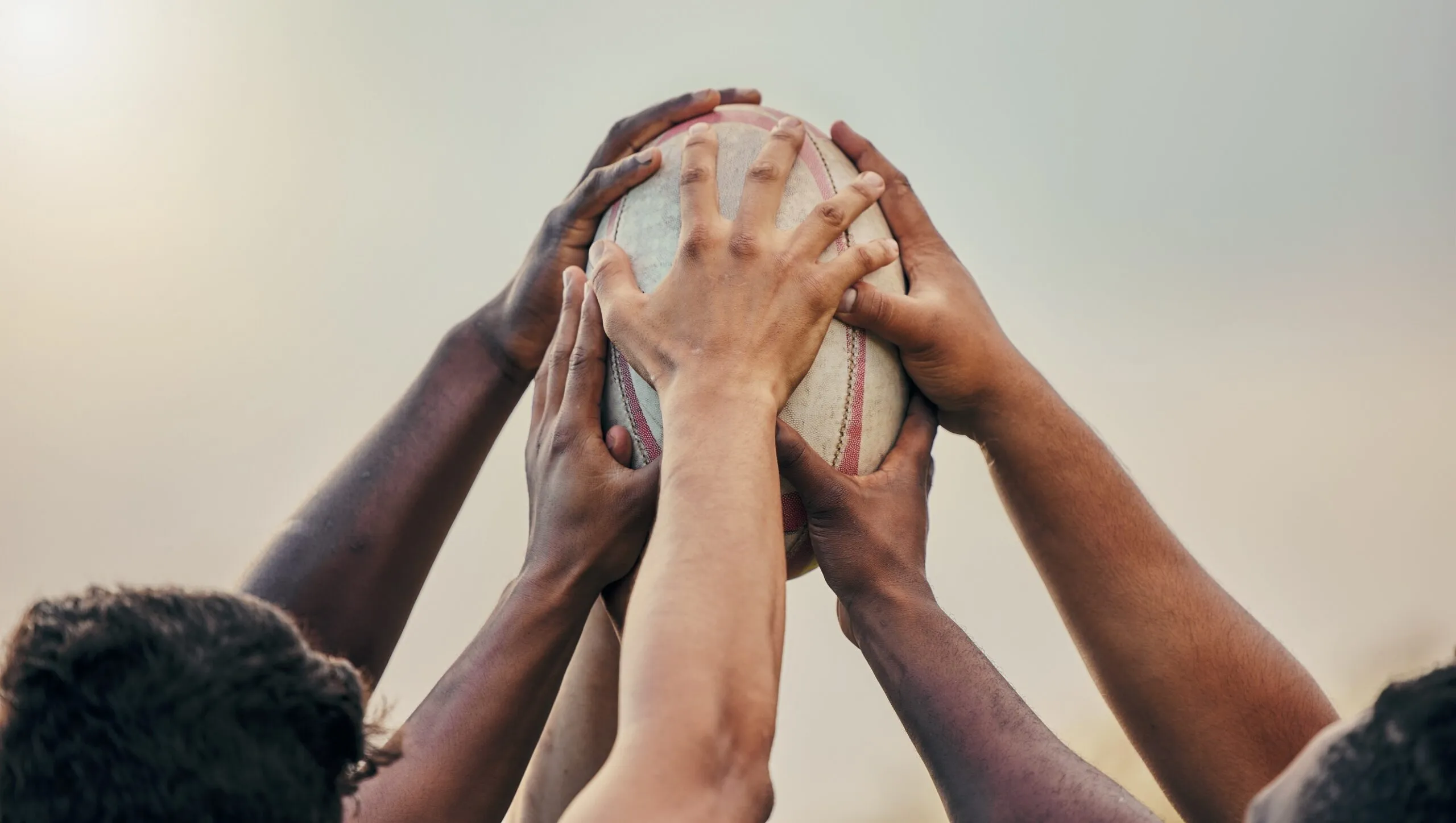 Diversity,,team,and,hands,together,in,sports,on,rugby,ball